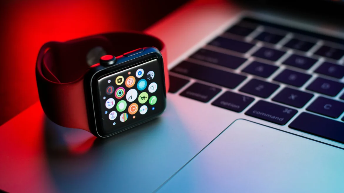 Apple Watch 2025 com tela mostrando aplicativos ao lado de laptop em mesa moderna