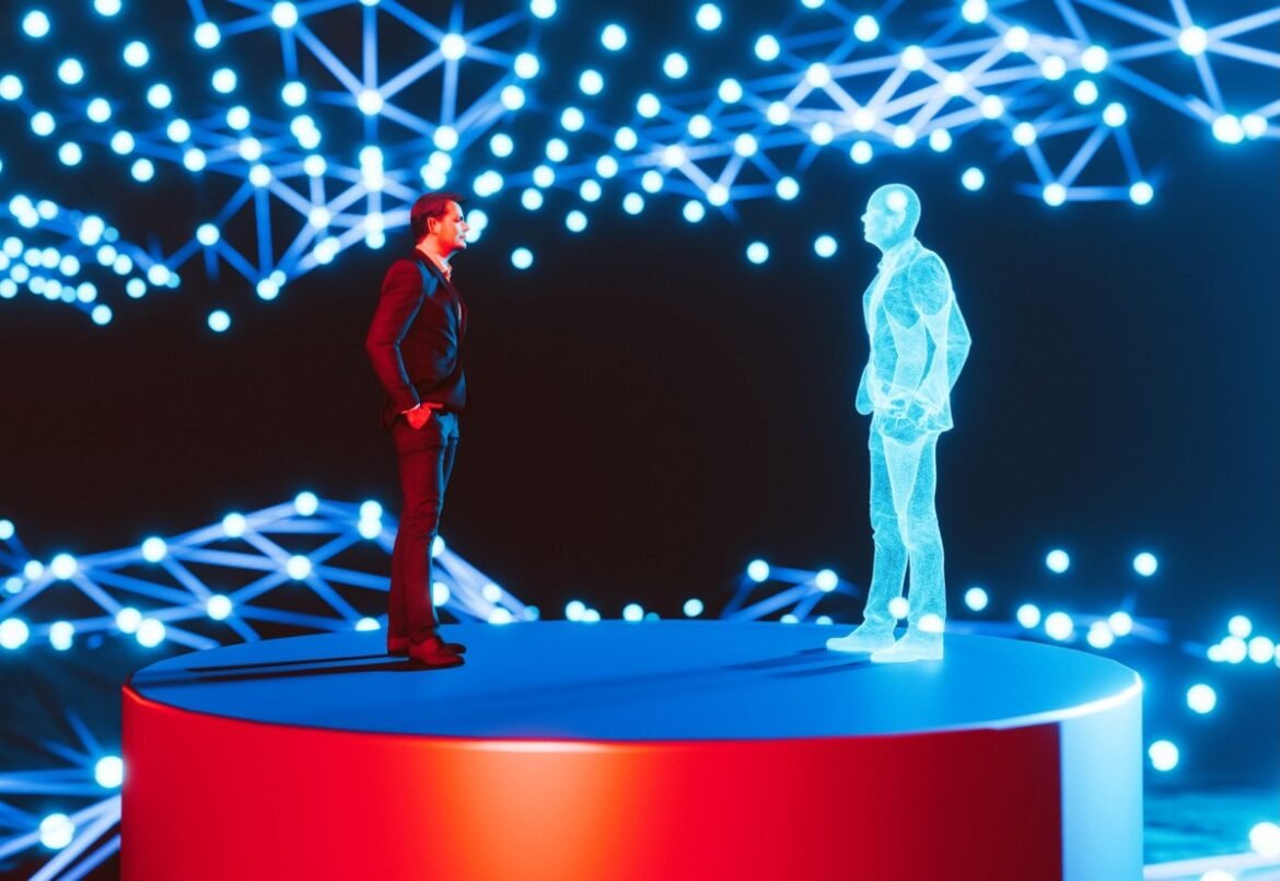 Man standing on a red platform, facing a holographic digital twin of himself. The background features a network of interconnected blue lights, creating a futuristic and high-tech atmosphere. The scene represents concepts of digital twins, virtual reality, and advanced technology.