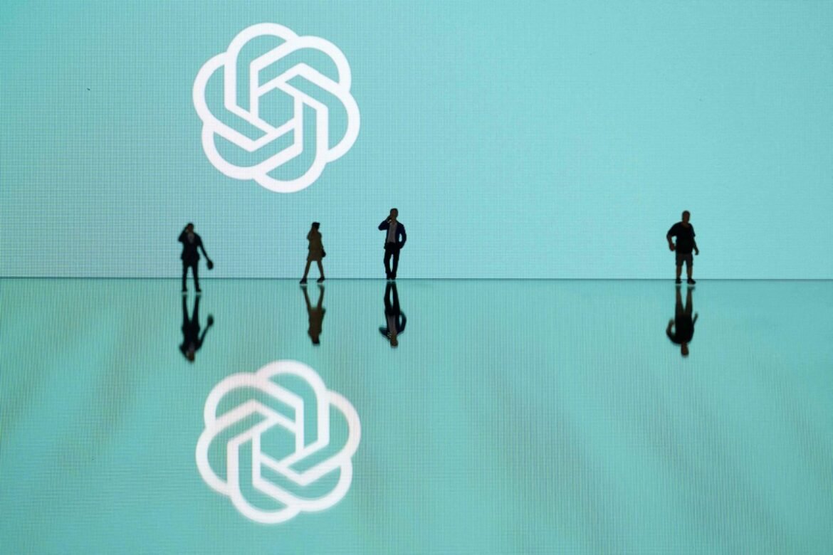 This photograph taken in Mulhouse, eastern France on October 19, 2023, shows figurines next to the ChatGPT logo. (Photo by SEBASTIEN BOZON/AFP via Getty Images)