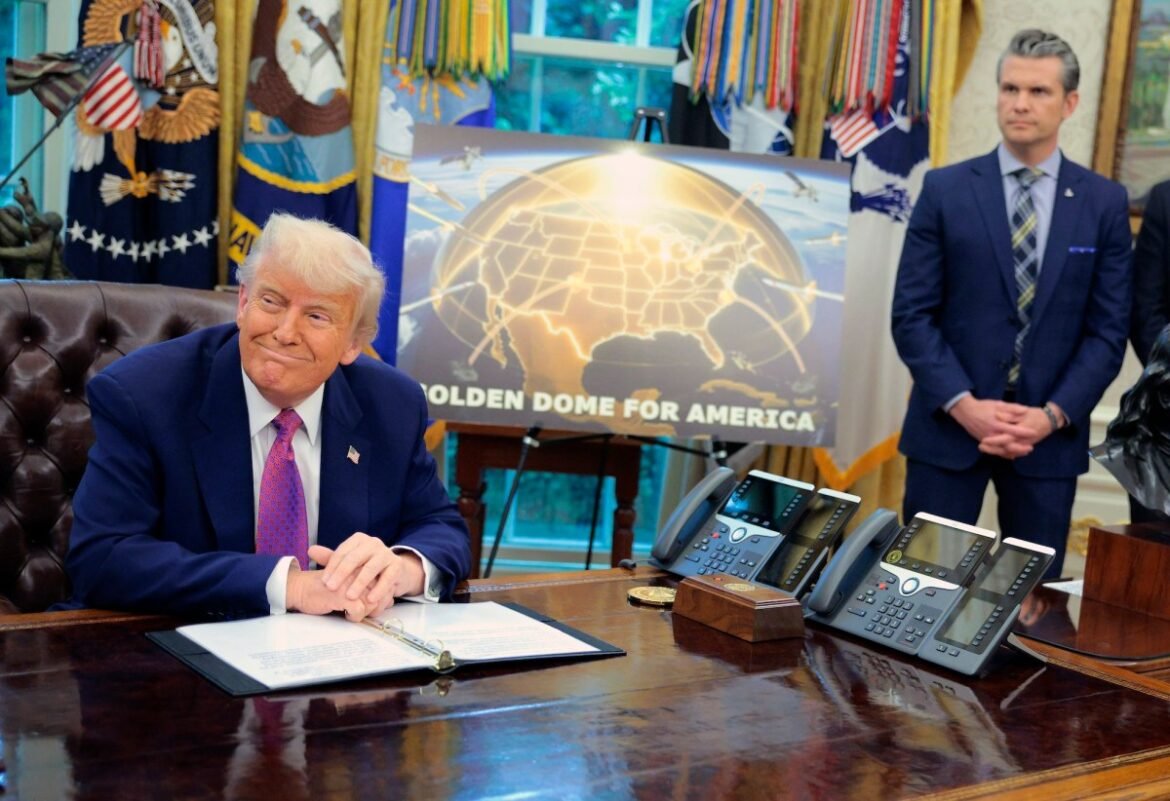 Golden Dome missile program placard with Trump sitting at desk